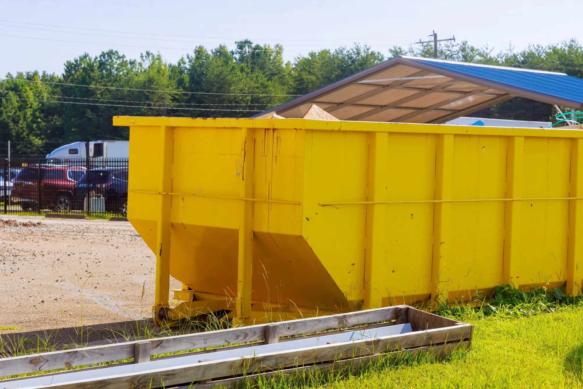 Yellow Bin dumpster filled with leaves and yard waste in fall